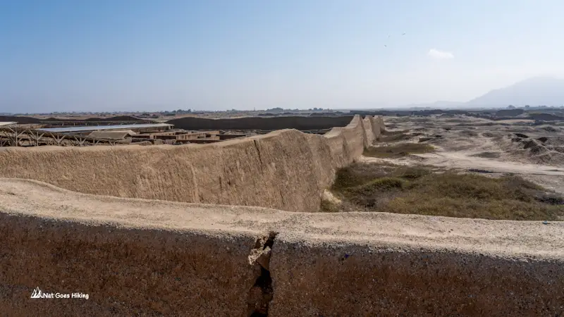 Eroded outer adobe wall stretching across the Chan Chan site, Peru