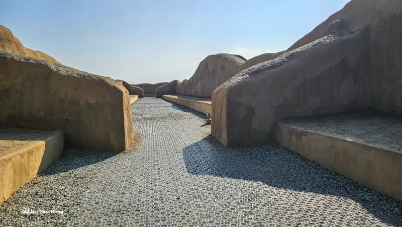 Modern walkway between eroded adobe walls at Chan Chan
